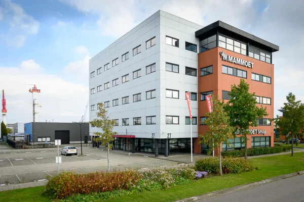 Kantoorgebouw van Mammoet aan de Karel Doormanweg met parkeerterrein en omliggend groen.